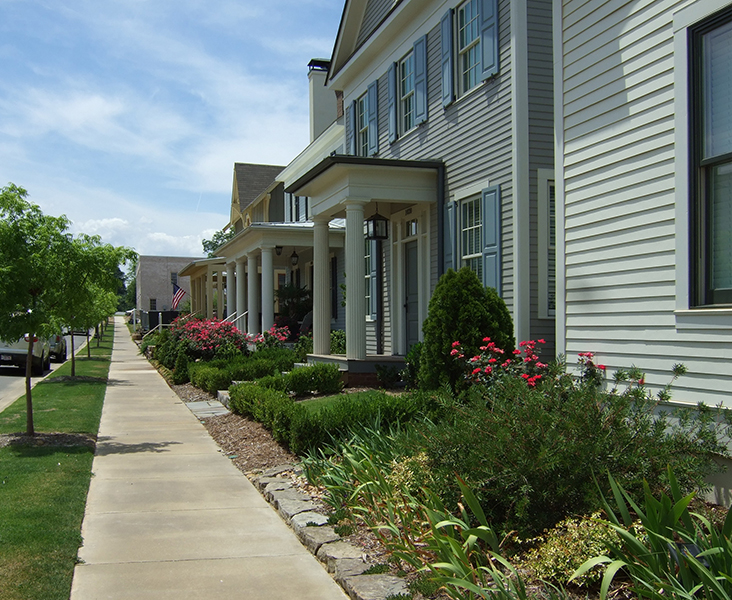 A row of houses next to a sidewalk