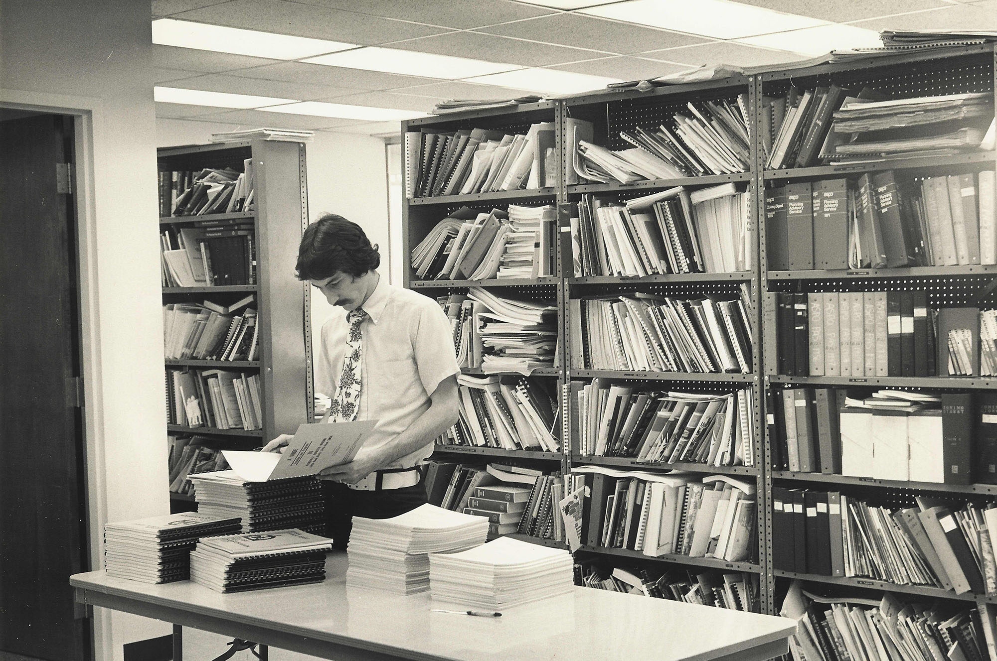 Man standing in front of a full bookshelf