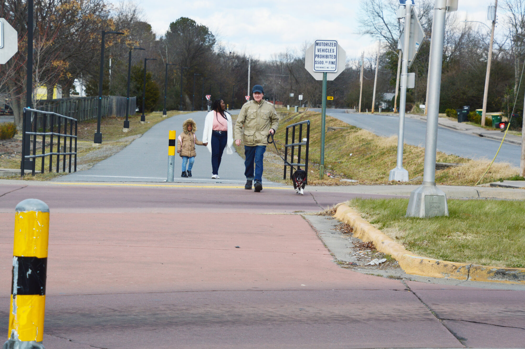 Pedestrians on a trail about to cross a street