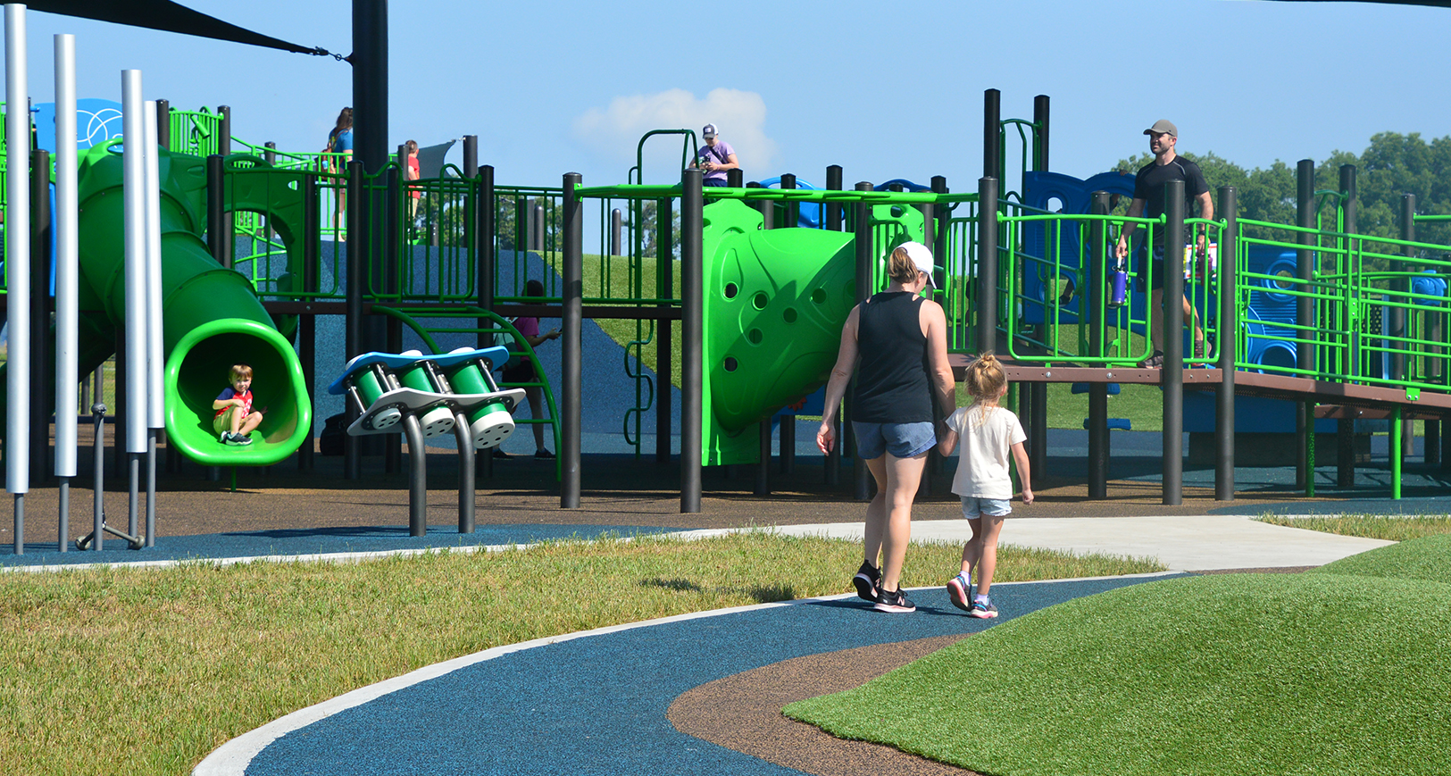 An adult and a child walking on a playground